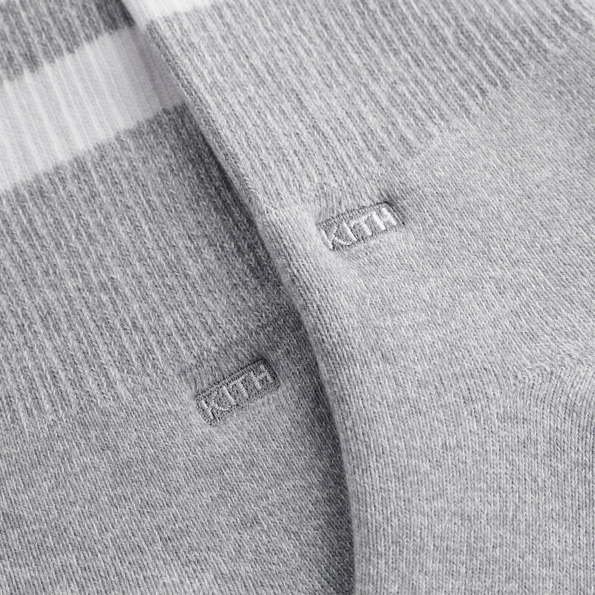 Close-up of white KITH box labels on the grey striped and plain cotton socks