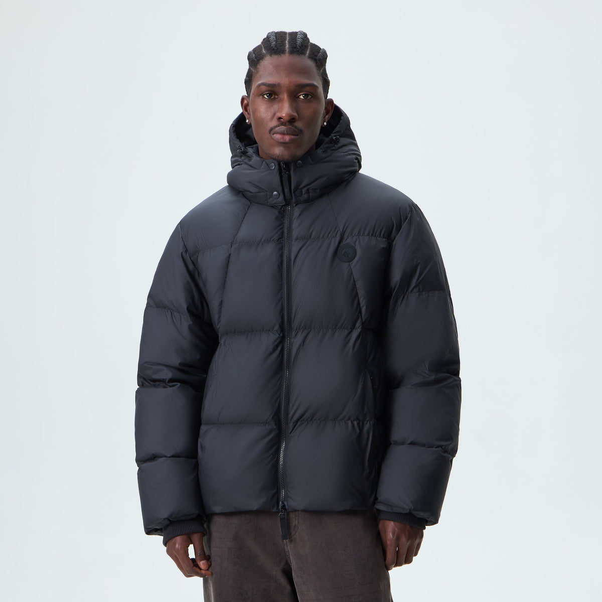 Man wearing black Kith Matte Stretch Taffeta midi puffer jacket, front view