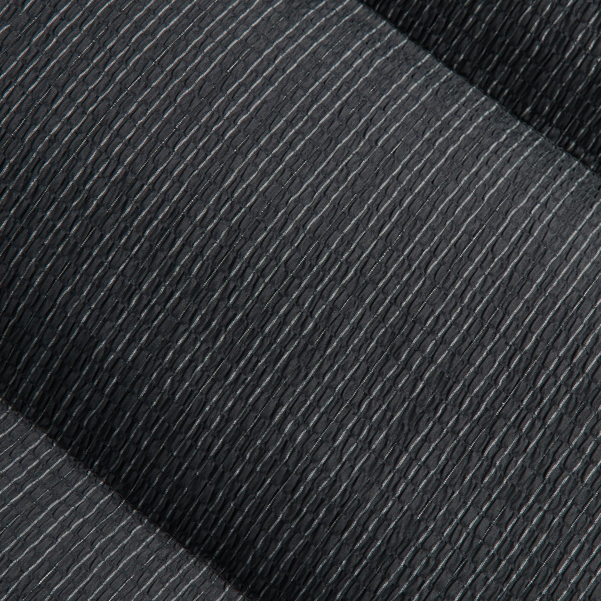 Close-up of the pleated ribbed charcoal fabric of the Kith Maverick puffer