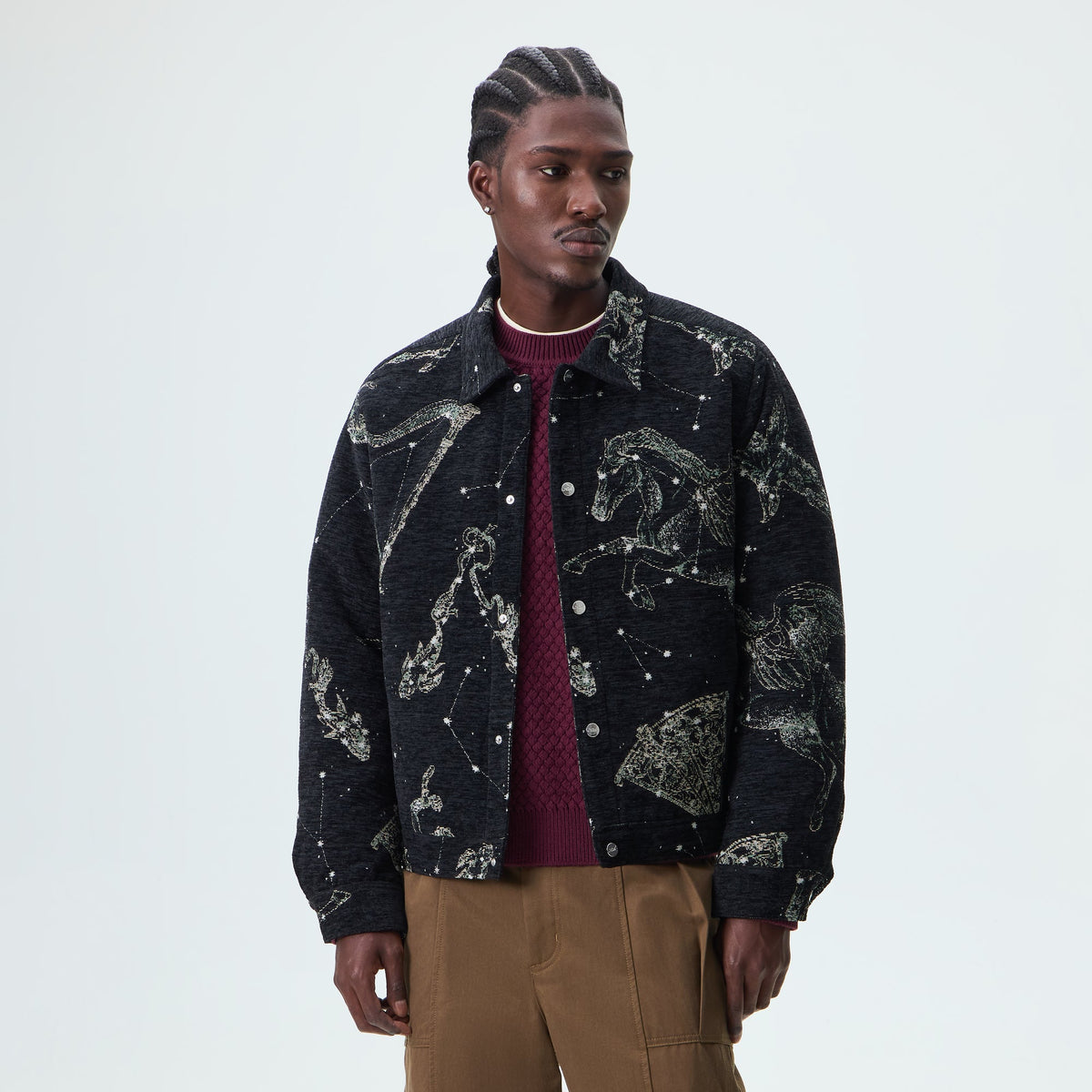 Man wearing black Kith Chenille Tapestry Helios jacket with constellation pattern, front view