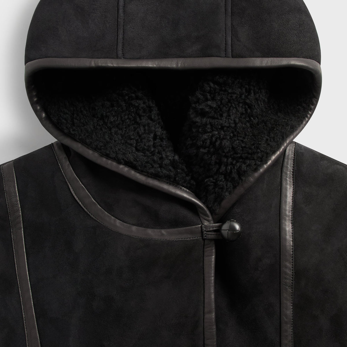Close-up of the shearling-lined hood and leather trim on the black &Kin Rio jacket