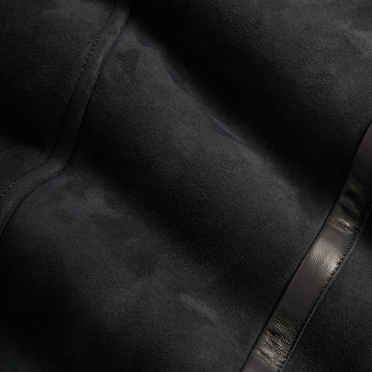 Close-up of black suede fabric of the &Kin Shearling Rio jacket