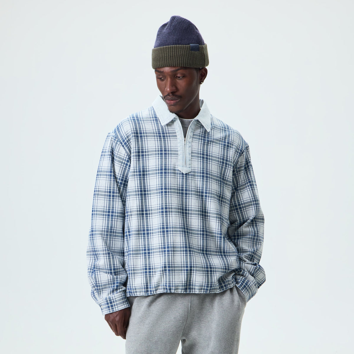 Man wearing blue plaid Kith Plaid Jersey Kurt quarter-zip pullover, front view