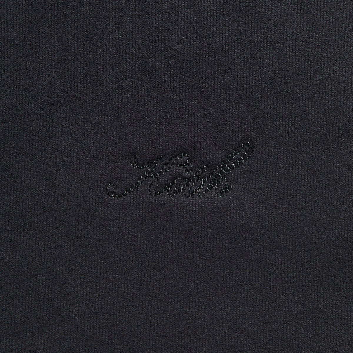 Close-up of the tonal 'Kith' script on the black Sueded French Terry Nelson rugby pullover