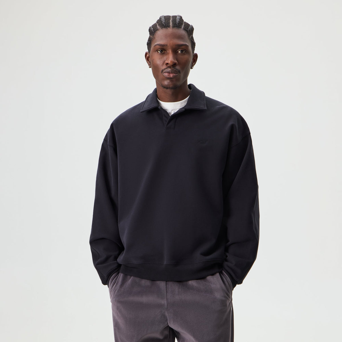 Man wearing black Kith Sueded French Terry Nelson rugby polo pullover, front view