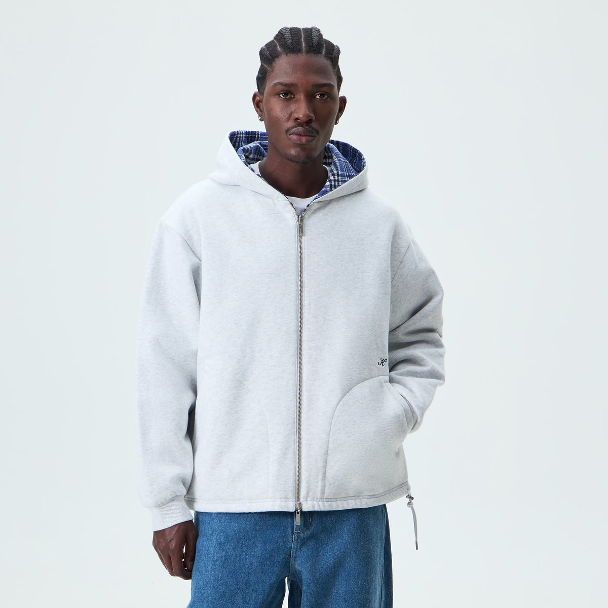 Man wearing the light heather grey side of the Kith Reversible Khenny zip-up hoodie, front view