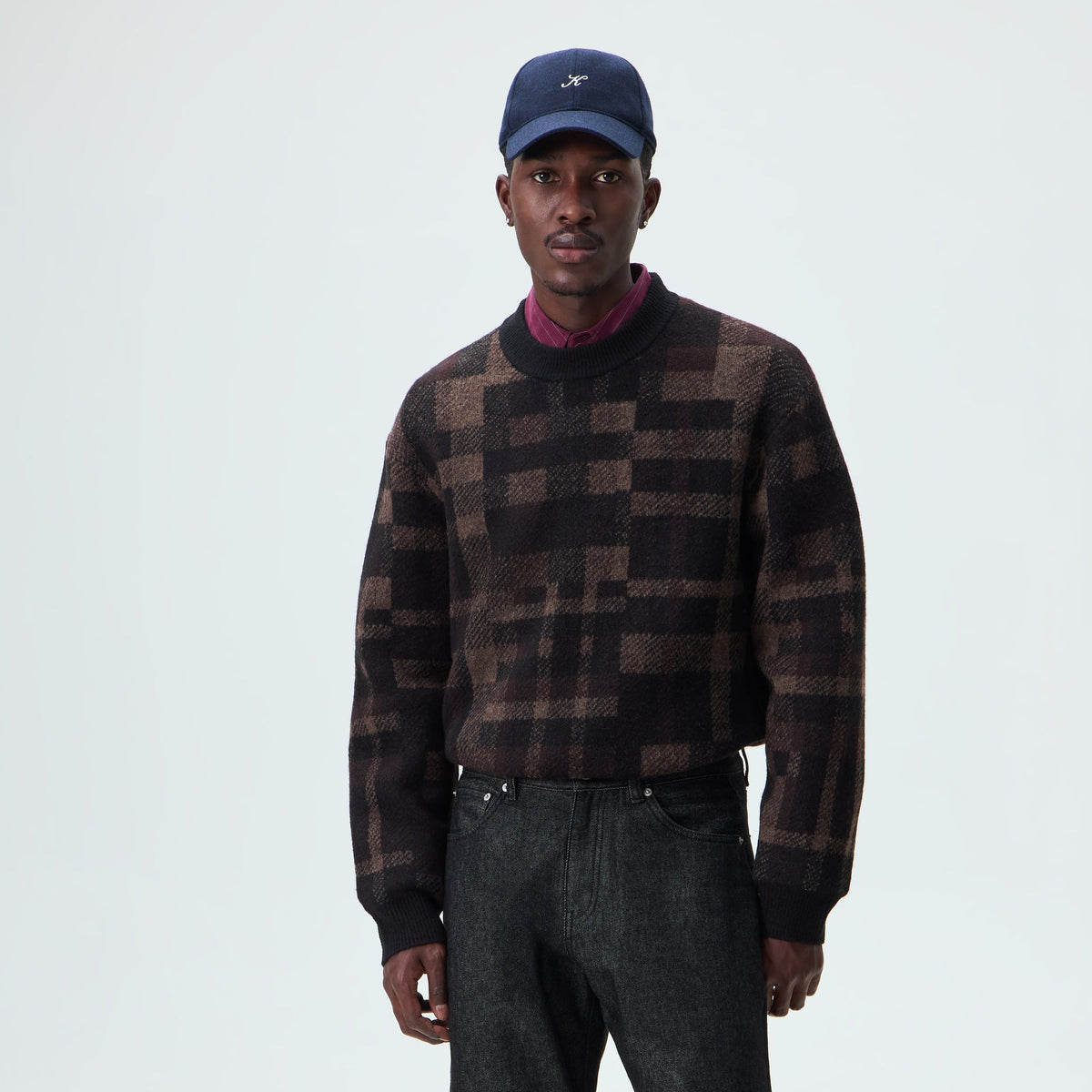 Man wearing the black and brown check Kith Lewis crewneck sweater, front view