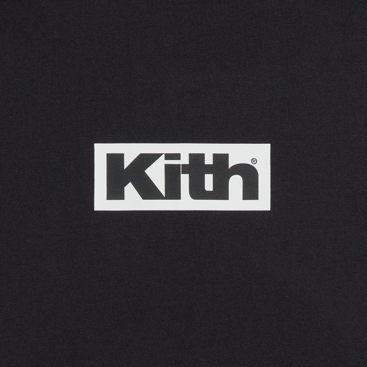 Close-up of the white Kith box logo on the black Retro Logo tee